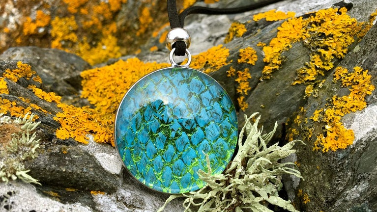 Necklace with scale pattern on rocks by the shore.